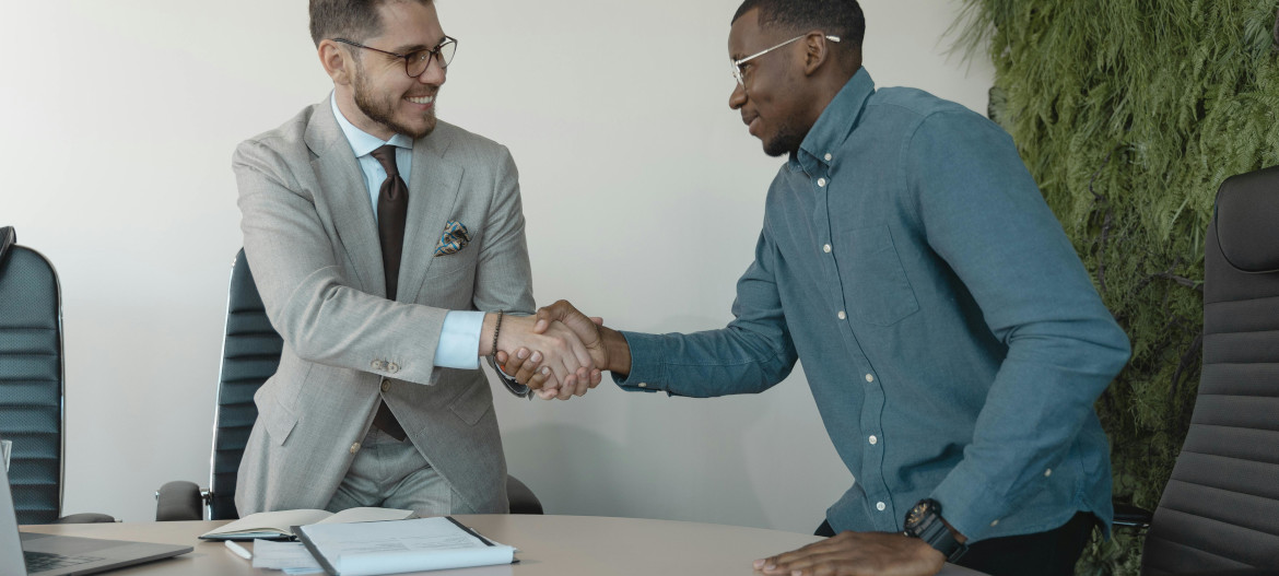 A hiring manager shaking hands with a potential staff member.